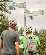 Foto mit zwei Radfahrern an einer Radwegebeschilderung Foto mit zwei Radfahrern an einer Radwegebeschilderung